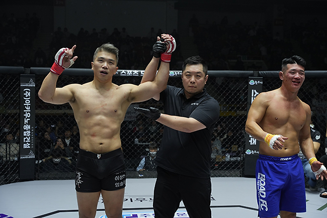 임동환(왼쪽)이 로드FC 미들급 잠정 챔피언 결정전 승리 선언을 받고 있다. 오른쪽은 제6대 로드FC 미들급 챔피언 라인재. 사진=세계격투스포츠협회