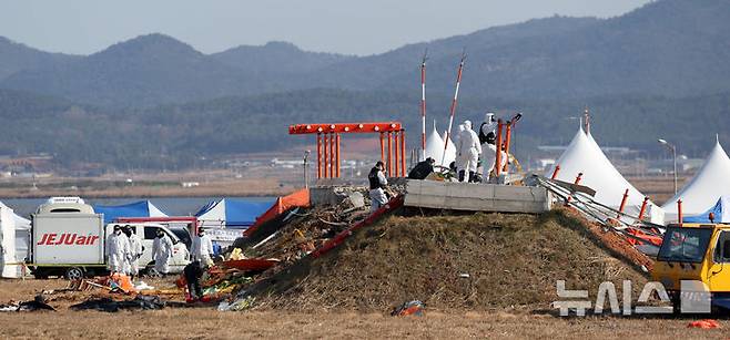 [무안=뉴시스] 김선웅 기자 = 지난 2일 전남 무안국제공항 제주항공 여객기 참사 현장에서 항공·철도사고 조사위원회(ARAIB) 관계자들이 로컬라이저(방위각 표시 시설)가 설치된 콘크리트 둔덕을 조사하고 있다.  2025.01.07. mangusta@newsis.com