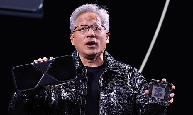 젠슨 황 엔비디아 최고경영자(CEO)가 세계 최대 IT(정보기술)·가전 전시회 'CES 2025' 개막을 하루 앞둔 6일(현지시간) 미국 네바다주 라스베이거스 만달레이베이 컨벤션센터에서 가진 기조연설에서 최신 인공지능(AI) 가속기 '블랙웰(Blackwell)'을 탑재한 지포스 RTX 50 시리즈 그래픽 카드를 공개하고 있다. 라스베이거스=뉴스1