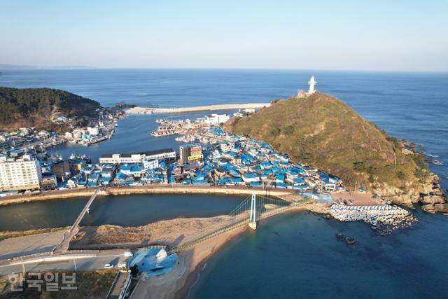 죽도산 아래 파란 지붕 집들이 모여 있는 축산항 풍경. 뒤편에는 블루로드다리가 놓여 있다.