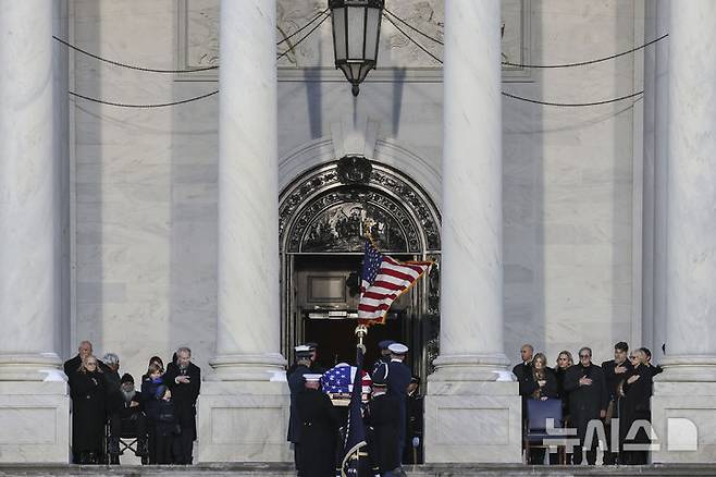 [워싱턴=AP/뉴시스] 지미 카터 전 미국 대통령의 운구 행렬이 7일(현지시각) 미국 워싱턴D.C. 국회의사당으로 향하고 있다. 카터 전 대통령의 운구는 이날 오전 조지아주 애틀란타 카터센터를 출발해 미 의회 중앙홀에 일시 안치돼 연방 상·하원 의원들이 참석한 가운데 추도식이 거행됐다. 오는 9일 워싱턴 국립대성당에서 국가 장례식이 치러진다. 2025.01.08.