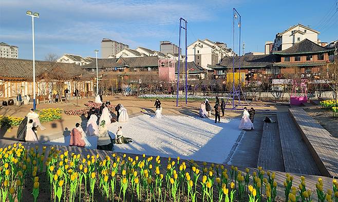 관광객들이 지난 2024년 12월 28일 중국 연변조선족자치주 연길시 조선족문화원에서 씨름판을 배경 삼아 기념사진을 찍고 있다.