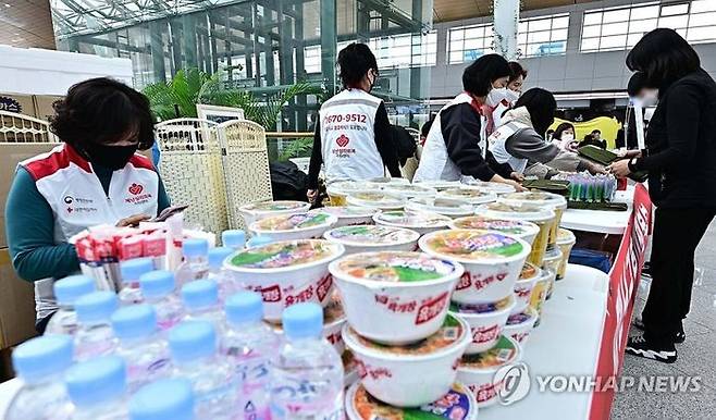 무안공항 대합실에서 각종 구호품 나눠주는 자원봉사자.ⓒ연합뉴스