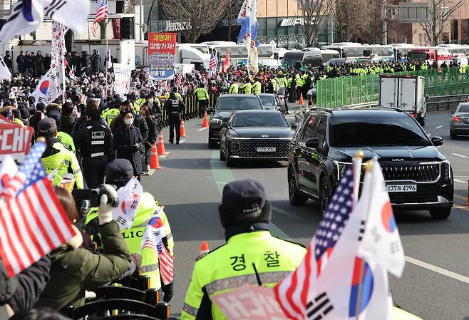 고위공직자범죄수사처가 내란죄 피의자 윤석열 대통령의 체포영장 집행을 중단한 지난 3일 오후 서울 용산구 대통령 관저에서 나온 공수처 차량들이 윤 대통령 지지 집회 옆을 지나고 있다. 김영원 기자 forever@hani.co.kr