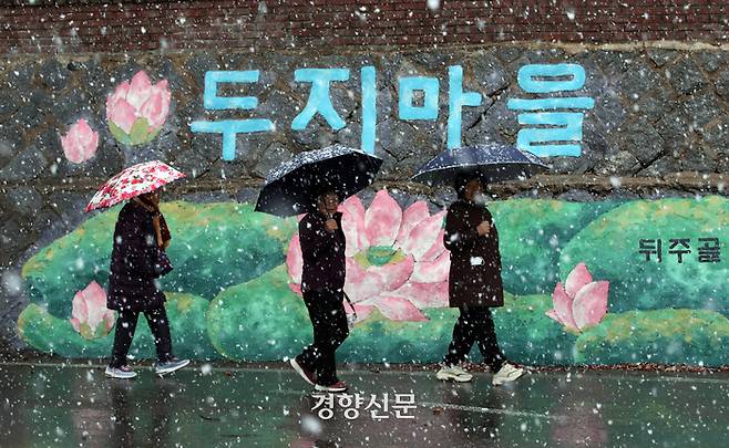 첫눈이 내린 지난 11월27일 전북 순창군 풍산면 ‘두지마을’ 주민들이 우산을 쓰고 버스정류장으로 걸어가고 있다. 서성일 선임기자