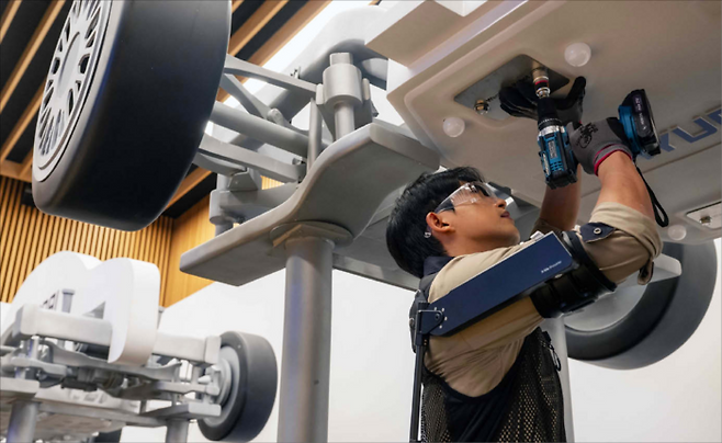 2024년 11월 27일 경기 고양시 ‘현대 모터스튜디오 고양’에서 열린 웨어러블 로봇 테크데이에서 현대차 직원이 산업용 착용 로봇 ‘엑스블 숄더’를 입고 볼트를 조이는 모습. (현대차그룹 제공)