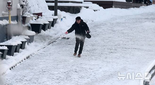 [전주=뉴시스] 김얼 기자 = 밤사이 전북지역에 많은 양의 눈이 내린 지난 8일 전북 전주시 전주한옥마을에서 한 시민이 제설작업을 하고 있다. 2025.01.08. pmkeul@newsis.com