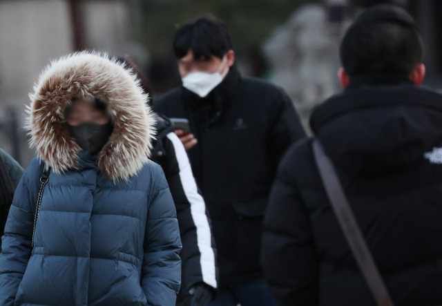 전국 아침 기온이 영하로 떨어진 7일 오전 서울 광화문 부근에서 시민들이 출근을 하고 있다. 연합뉴스