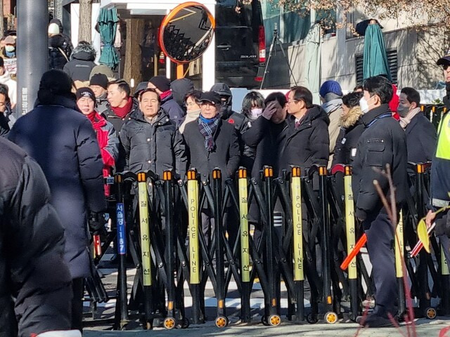 10일 서울 용산구 한남동 윤석열 대통령 관저 앞에 세워진 경찰 질서유지선 안에 국민의힘 원외 당협위원장들이 서 있는 모습. 고나린 기자