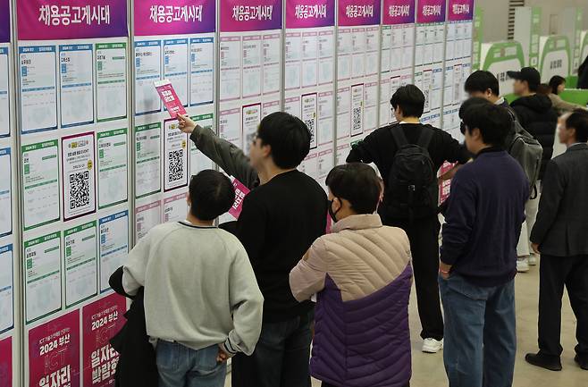 ICT 기술과 인재를 연결하는 2024 부산 ICT 일자리 박람회가 열린 20일 오전 부산 해운대구 벡스코 제2전시장에서 구직자들이 채용공고 게시판을 살펴보고 있다. [연합]