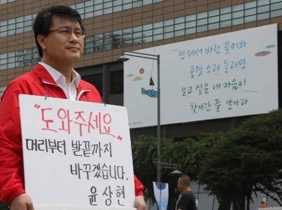 윤상현 당시 새누리당 사무총장이 1일 광화문 네거리 이순신 동상 앞에서 투표를 독려하는 피켓시위를 하고 있다. 2014.6.1 연합뉴스