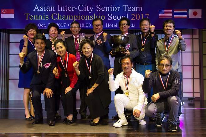 김문일 대표(뒷줄 왼쪽에서 네 번째)가 2017년 서울 올림픽코트에서 열린 아시아 도시대항 시니어팀 테니스대회를 개최한 뒤 호텔에서 기념사진을 찍었다. 김문일 대표 제공.