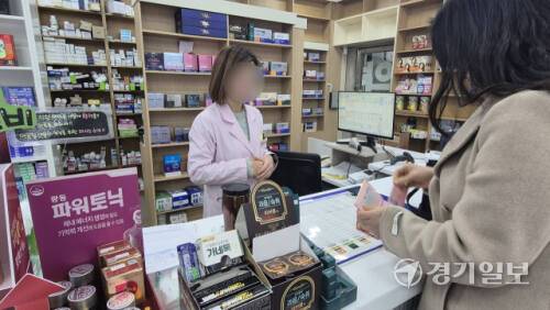 11일 오전 용인시 수지구 풍덕천동의 한 약국에서 마스크를 낀 소비자가 성인용 종합감기약을 구매하고 있다. 금유진기자