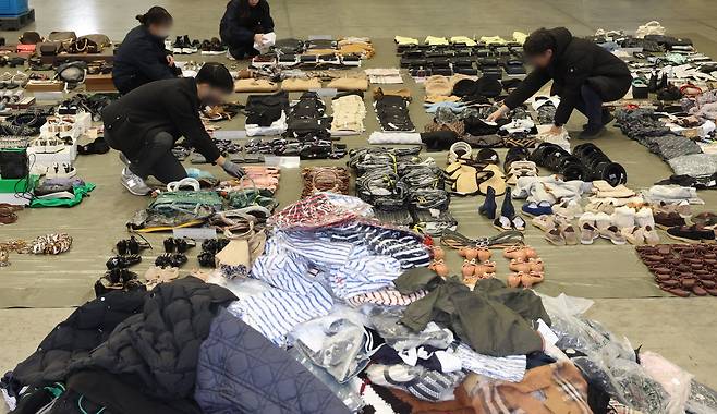 On Jan. 9, at the designated storage facility of Busan Customs in Gangseo District, Busan, customs officials sorted through over 10,000 counterfeit items from China, worth an estimated 20 billion won, seized from a distributor. /Yonhap News
