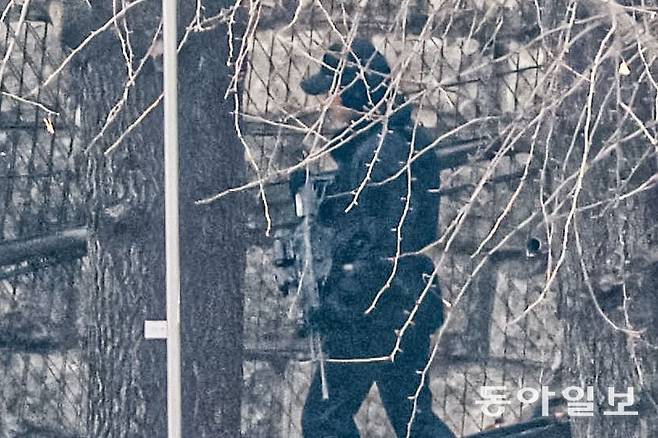 고위공직자범죄수사처의 윤석열 대통령 체포영장 집행이 임박한 가운데 13일 서울 용산구 한남동 대통령 관저 외곽에서 55경비단으로 추정되는 한 경호병력이 K2C1 소총을 들고 관저 외곽을 순찰하고 있다. 박형기 기자 oneshot@donga.com