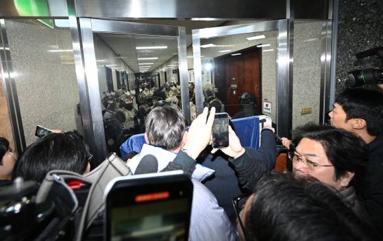 윤석열 대통령이 전격적으로 비상계엄령을 선포한 4일 새벽 계엄군들이 국회 본청 진입을 시도하자 국회 보좌진 등 직원들이 대치하고 있다. 뉴스1