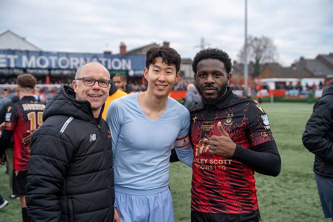 토트넘 홋스퍼 주장 손흥민(가운데)이 탬워스와 경기가 끝난 뒤 상대 감독, 선수와 사진을 찍고 있다. /사진=탬워스 공식 사회관계망서비스(SNS)