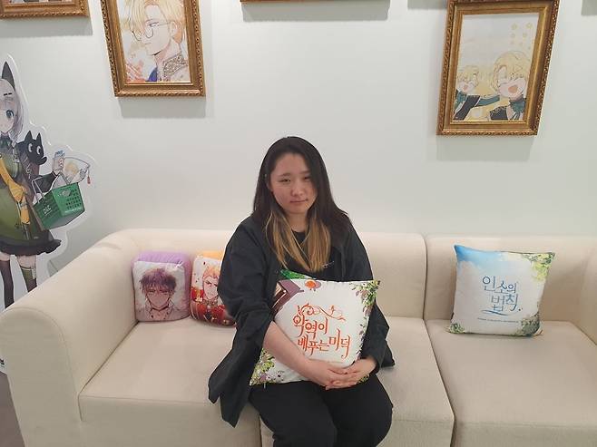 심세은 사원이 쿠션 굿즈를 들고 안고 있다. 윤현주 기자