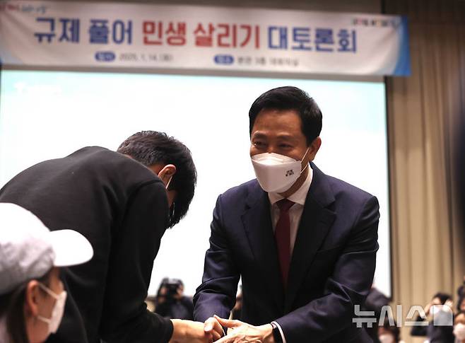 [서울=뉴시스] 김명년 기자 = 오세훈 서울시장이 14일 오후 서울 중구 시청에서 열린 ‘규제 풀어 민생 살리기 대토론회’에서 참석자와 악수하고 있다. 2025.01.14. kmn@newsis.com