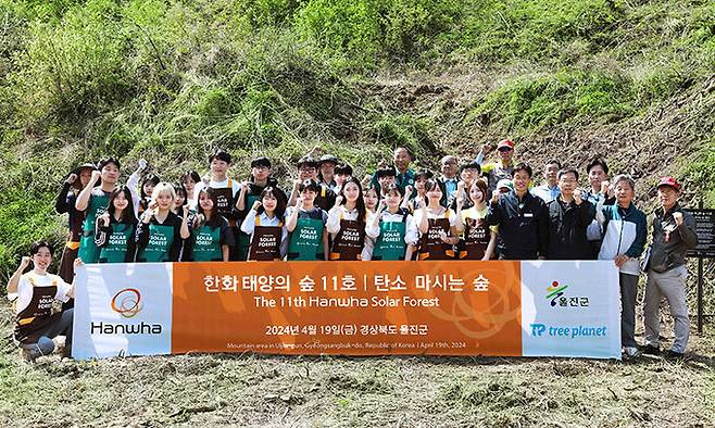 지난해 4월 경북 울진의 11호 ‘한화 태양의 숲’ 조성 참가자들이 기념 촬영을 하고 있다. 한화그룹 제공