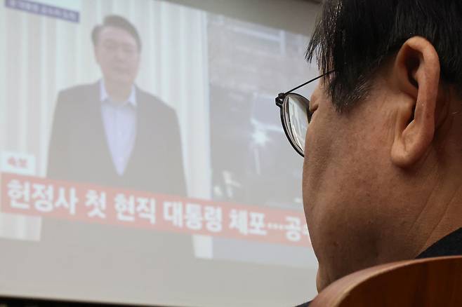 이재명 더불어민주당 대표가 15일 오전 서울 여의도 국회에서 열린 비상의원총회에서 윤석열 체포 뉴스를 시청하고 있다. /연합뉴스