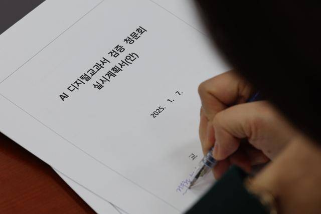 7일 오전 서울 여의도 국회에서 열린 교육위원회 전체회의에서 한 의원이 AI디지털교과서 검증 청문회 실시계획서에 글씨를 적고 있다. 뉴시스