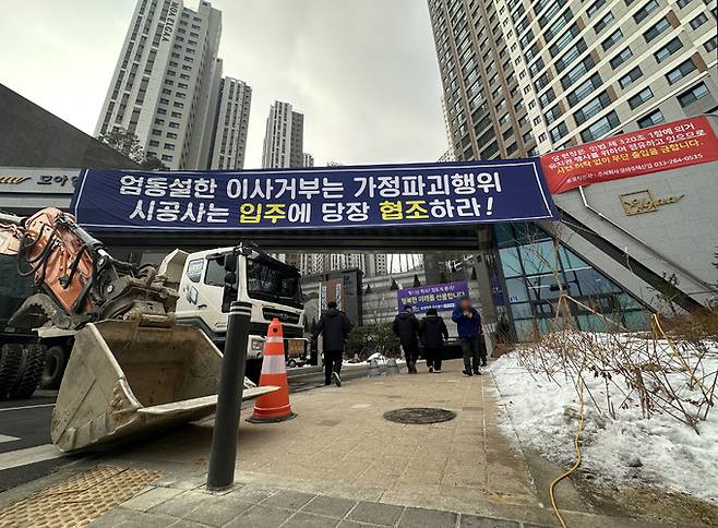 지난 13일 강원 춘천시 학곡리 모아엘가 비스타 민간 임대 아파트 문주 앞에서 시공사가 덤프트럭과 포크레인으로 차량 출입을 막으며 유치권을 행사하고 있다. 연합뉴스