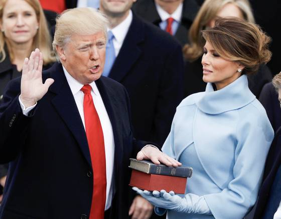 도널드 트럼프 미국 대통령 당선인이 2017년 1월 20일 제45대 대통령에 취임하며 선서를 하고 있다. 오른쪽은 부인 멜라니아 여사. 로이터=연합뉴스