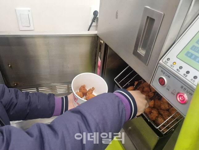 점원이 튀김기에서 치킨을 꺼내고 있다. 15분 정도 시간이 걸렸다. (사진=한전진 기자)