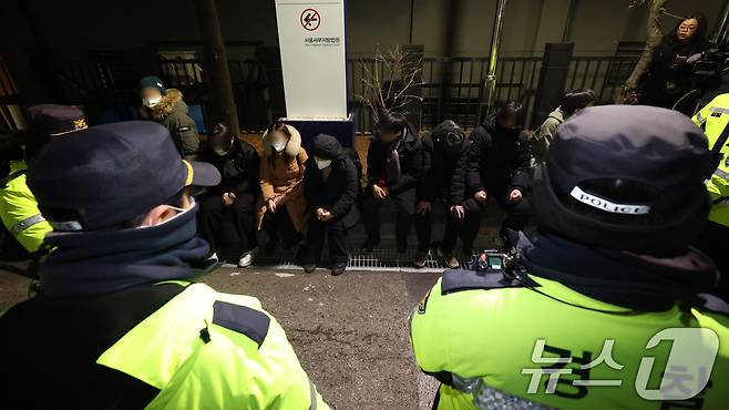 내란 우두머리 혐의로 체포된 윤석열 대통령의 영장실질심사가 열린 18일 오후 서울 마포구 서울서부지방법원에서 윤 대통령의 석방을 촉구하며 법원 담장을 넘어 들어온 청년들이 경찰에 붙잡혀 있다.(공동취재) 2025.1.19/뉴스1 ⓒ News1 민경석 기자