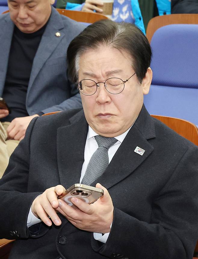 더불어민주당 이재명 대표가 19일 국회에서 열린 비상의원총회에 입장해 휴대폰을 살펴보고 있다./연합뉴스