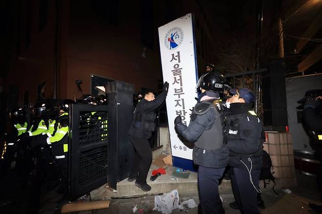 윤석열 대통령 지지자들이 19일 서울서부지방법원을 습격한 오전 경찰이 법원 후문에서 쓰러진 현판을 세우고 있다. /사진=연합뉴스