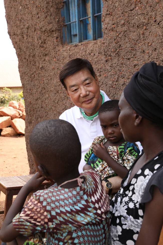 황영기 초록우산 회장이 지난해 6월 기관이 후원하고 있는 르완다의 한 가정집을 찾아 부모와 대화를 나누고 있다.  초록우산 제공