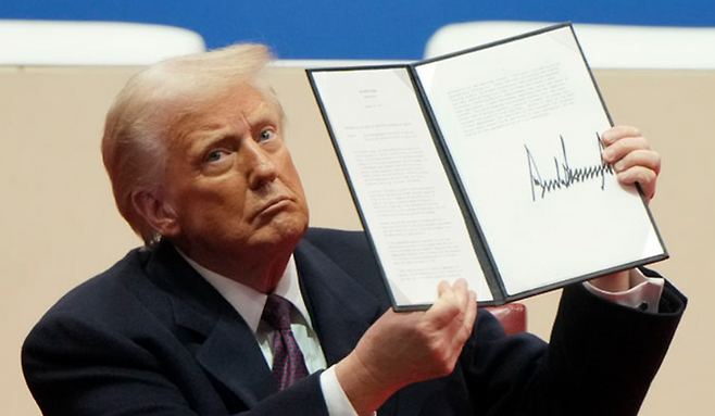 도널드 트럼프 미국 대통령이 20일(현지시간) 워싱턴DC 캐피털원아레나에서 행정명령 1호에 서명한뒤 지지자들에게 보여주고 있다. ⓒAP/뉴시스