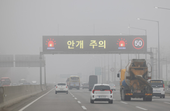 21일 오전 짙은 안개가 가득한 인천공항고속도로 영종대교 구간을 차량이 시속 50㎞로 운행하고 있다.   이날 인천공항고속도로 해안 부근에는 가시거리 50m 수준의 짙은 안개가 꼈다. 연합뉴스