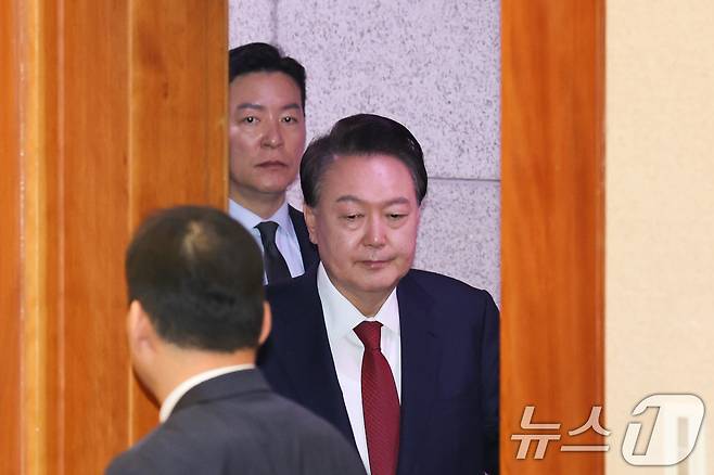 윤석열 대통령이 지난 21일 오후 서울 종로구 헌법재판소에서 열린 탄핵심판 3차 변론에 김성훈 대통령 경호처 차장의 경호를 받으며 출석하고 있다. 2025.1.22/뉴스1 ⓒ News1 사진공동취재단