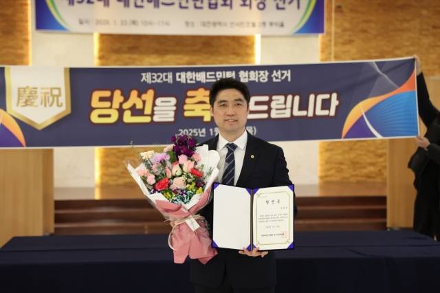 김동문 교수가 23일 대전 동구 호텔선샤인에서 열린 제32대 대한배드민턴협회장 선거에서 당선된 뒤 당선증을 들고 기념촬영을 하고 있다. 대한배드민턴협회 제공