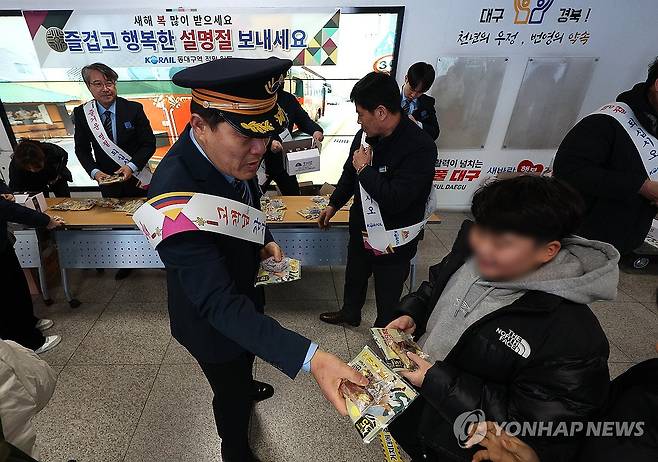 '즐거운 명절 보내세요' (대구=연합뉴스) 윤관식 기자 = 설 명절 연휴를 하루 앞둔 24일 동대구역에서 코레일 직원들이 열차 이용객들에게 떡과 손난로를 나눠주고 있다. 2025.1.24 psik@yna.co.kr