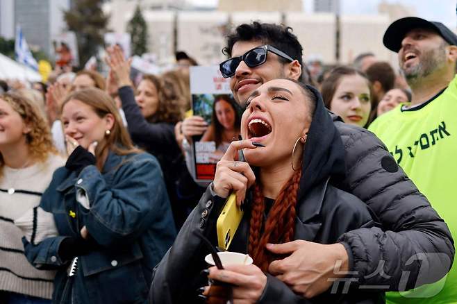 25일(현지시간) 이스라엘 텔아비브 인질 광장에서 시민들이 하마스로부터 풀려난 군인 인질의 석방 소식에 환호하고 있다. 2025.01.25/ ⓒ AFP=뉴스1 ⓒ News1 권진영 기자