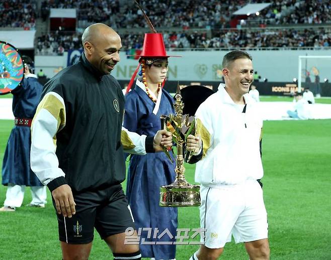 시대를 대표하는 레전드 축구 선수들이 'FC스피어'와 '실드 유나이티드' 팀을 구성, 스페셜매치를 치르는 ‘2024 넥슨 아이콘 매치'가 20일 오후 서울 마포구 서울월드컵경기장에서 열렸다. 경기 시작 전 앙리와 칸다바로 양팀 감독이 함께 대회 트로피를 들고 걷고 있다. 상암=김민규 기자 mgkim1@edaily.co.kr /2024.10.20/