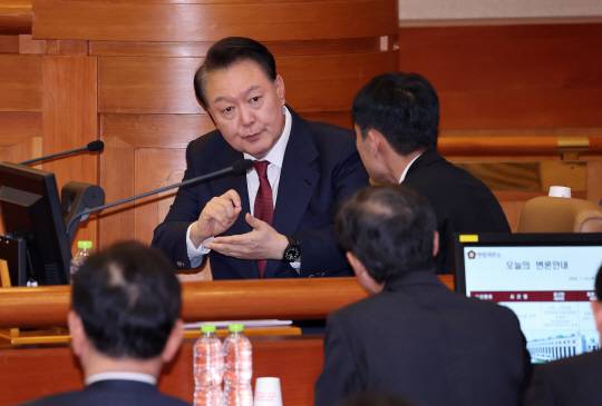 윤석열 대통령이 지난 23일 서울 종로구 헌법재판소에서 열린 탄핵심판 4차 변론에 출석해 변호인단과 대화를 나누고 있다. 사진공동취재단