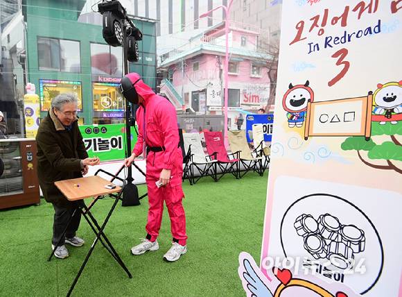 26일 오후 서울 마포구 홍대 레드로드 R1존 에어돔에서 '홍대 에어돔 K-유니버스 페스티벌'이 진행된 가운데 참가자가 오징어게임 공기놀이 체험을 하고 있다. [사진=정소희 기자]