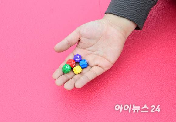 26일 오후 서울 마포구 홍대 레드로드 R1존 에어돔에서 '홍대 에어돔 K-유니버스 페스티벌'이 진행된 가운데 참가자가 오징어게임 공기놀이 체험을 하고 있다. [사진=정소희 기자]