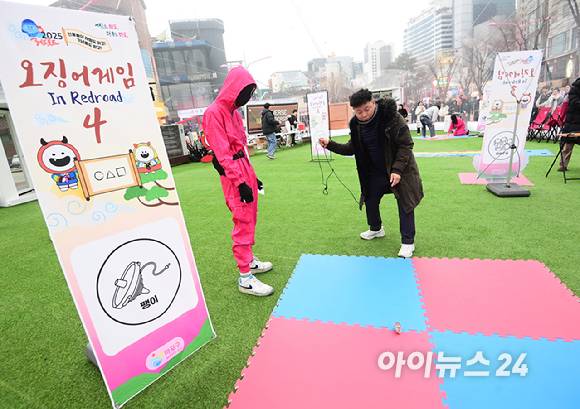 26일 오후 서울 마포구 홍대 레드로드 R1존 에어돔에서 '홍대 에어돔 K-유니버스 페스티벌'이 진행된 가운데 참가자가 오징어게임 팽이 돌리기 체험을 하고 있다. [사진=정소희 기자]