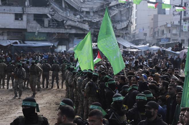 하마스 무장 대원들이 지난 25일  인질 석방 행사에 몰려든 군중을 통제하고 있다.