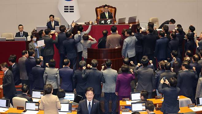 더불어민주당 이재명(가운데) 대표가 지난달 27일  국회 본회의장에서  한덕수 국무총리 탄핵소추안에 투표한 뒤 자리로 향하고 있다./연합뉴스