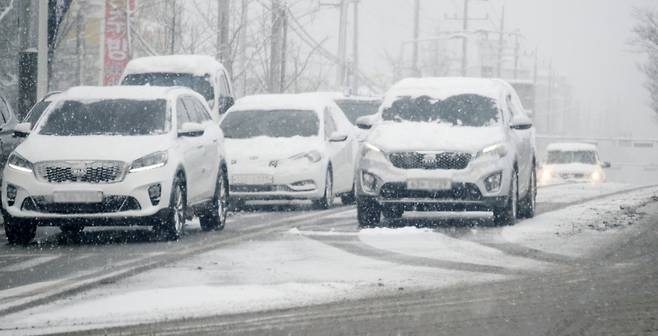 전북 전역에 대설특보가 발효된 28일 전북 전주시 덕진구 호성동 동부대로에 눈 쌓인 차량이 지나고 있다. [전주=뉴시스]