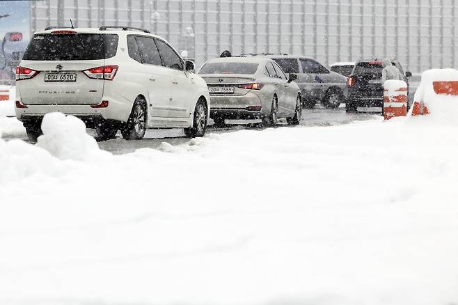 설 연휴 많은 양의 눈이 내린 28일 경기 용인시 기흥휴게소에서 차량들이 고속도로에 진입하고 있다. [용인=뉴시스]