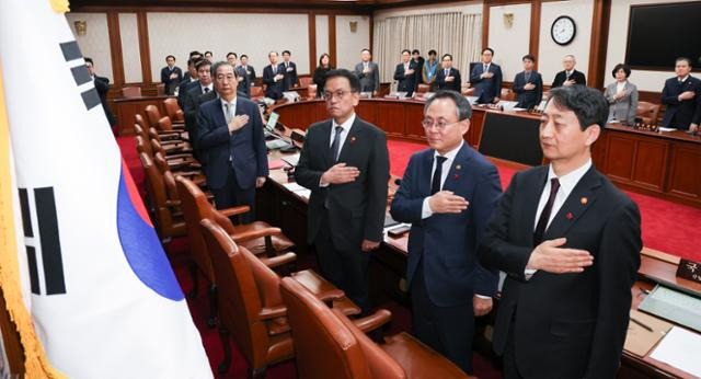 한덕수 당시 대통령 권한대행 겸 국무총리가 지난해 12월 14일 서울 종로구 정부서울청사에서 열린 임시 국무회의에서 국무위원들과 함께 국민의례를 하고 있다. 뉴스1