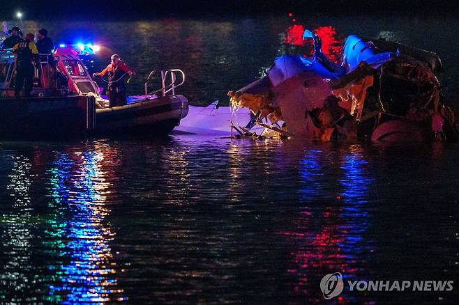 29일(현지시간) 미국 워싱턴 로널드 레이건 공항 인근에서 추락한 비행기 잔해를 수거하고 있는 수색대 [AFP=연합뉴스 자료사진. 재판매 및 DB금지]